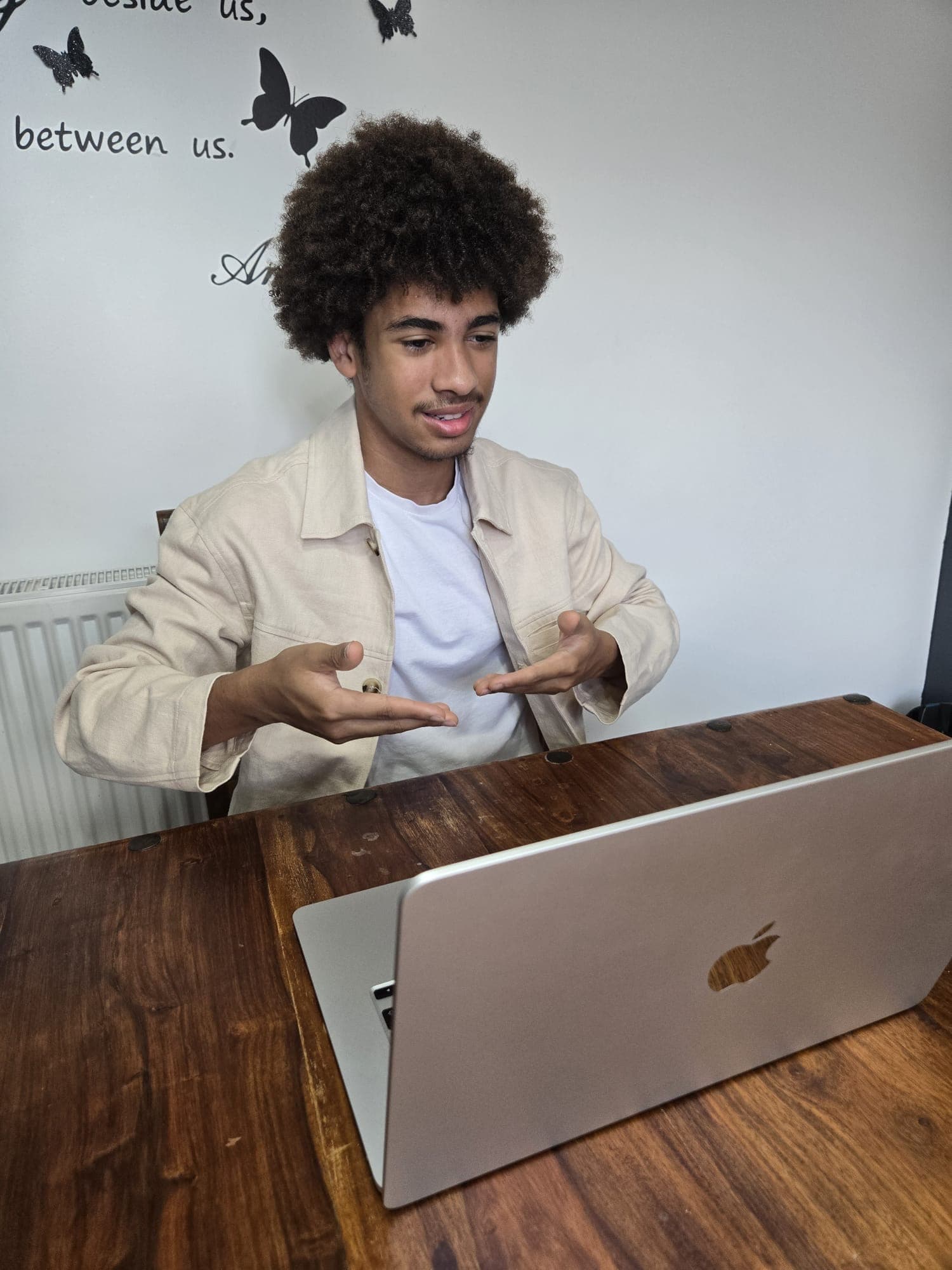 A tutor gesturing while speaking to a student during a live video call